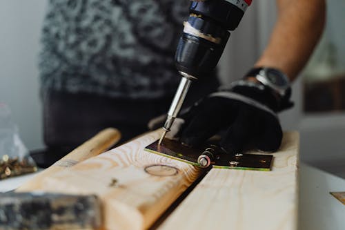 A Person Drilling a Screw