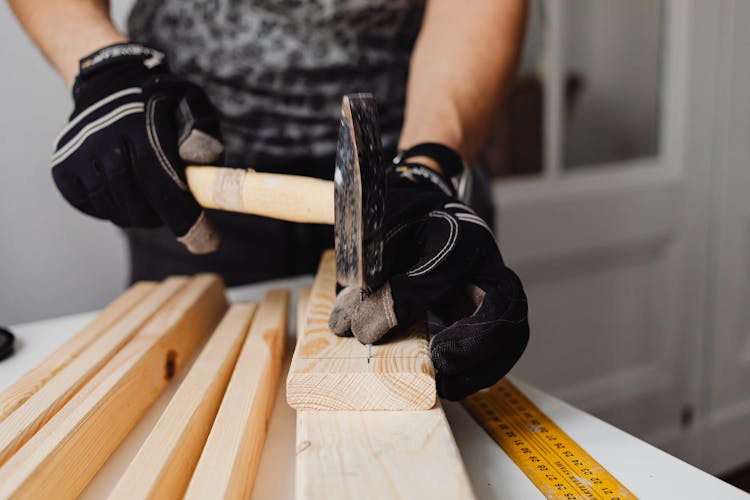 Close-up Photo Of Hammering Of Nail On A Wood Block 