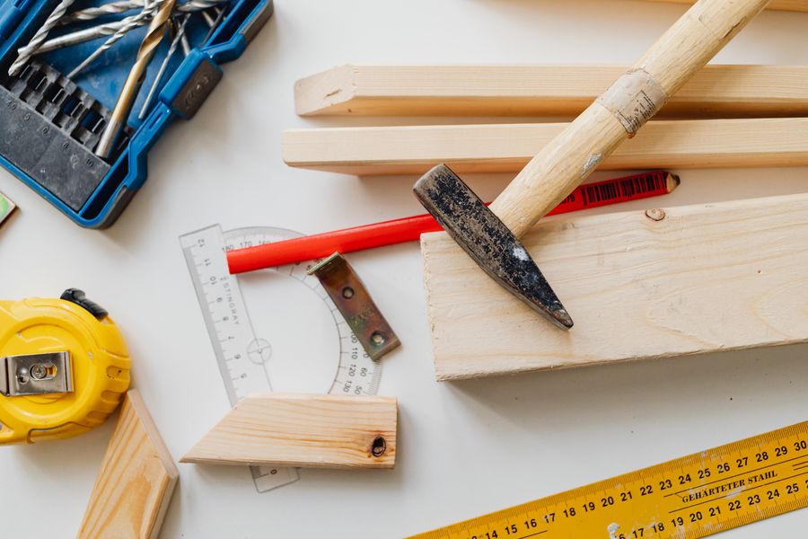 Rough sawn timber laid out beside a row of carpentry hand tools