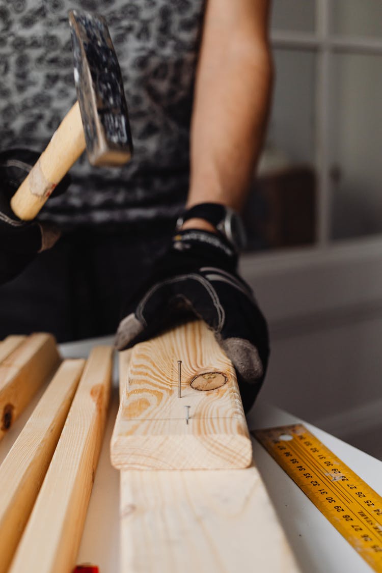 Close-up Photo Of Hammering Of Nail On A Wood Block