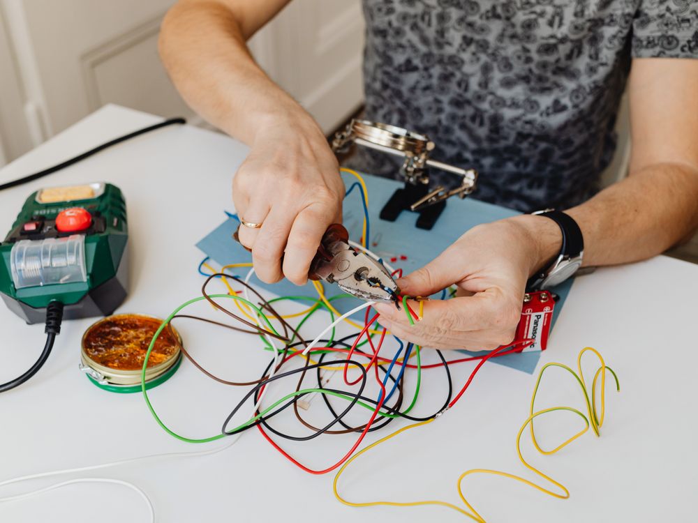 Auto electrician testing vehicle wiring with a multimeter
