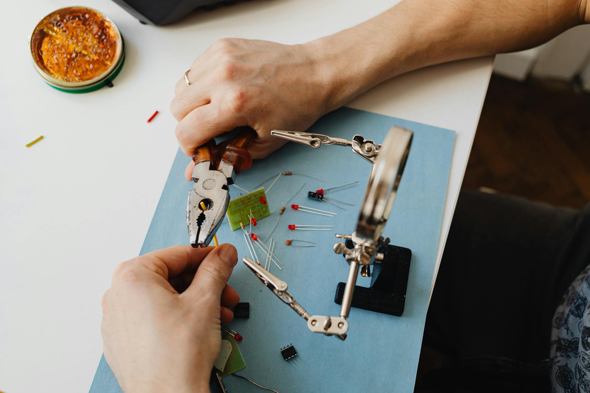 Hands of Person Assembling Transistors with Use of Magnifying Glass