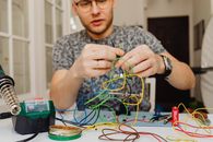Photo of a Man's Hands Holding Cables