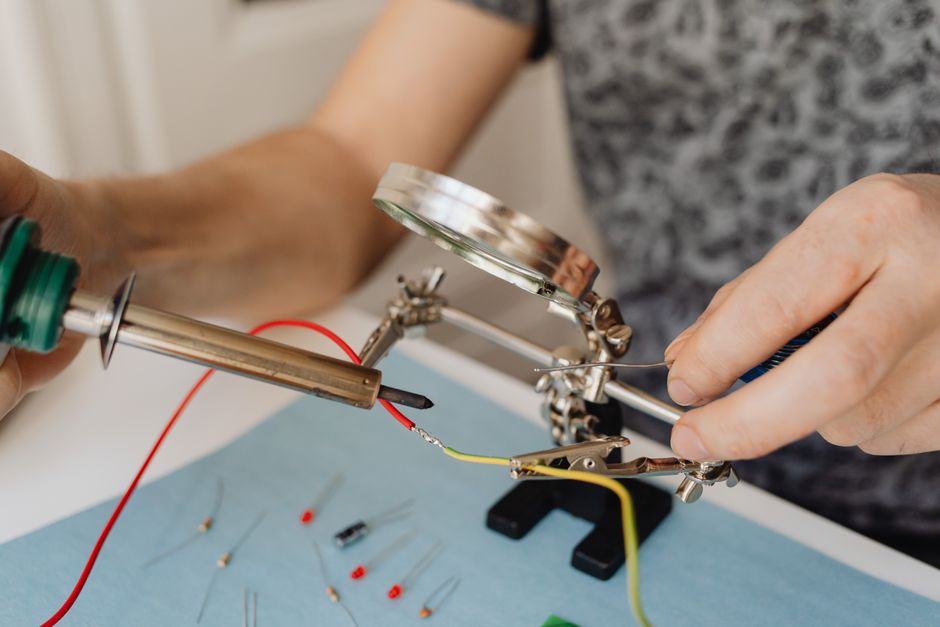 Close-up of soldering process with tools in electronics assembly.
