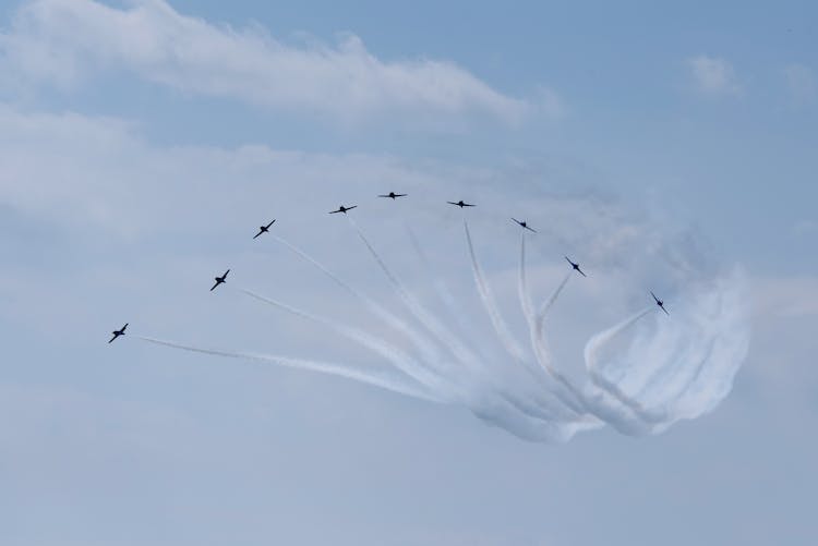 Aircrafts Creating Curved Air Traces In Cloudy Sky