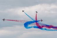 Low angle of aircrafts performing tricolor air tattoo with wavy traces on National Aviation Day