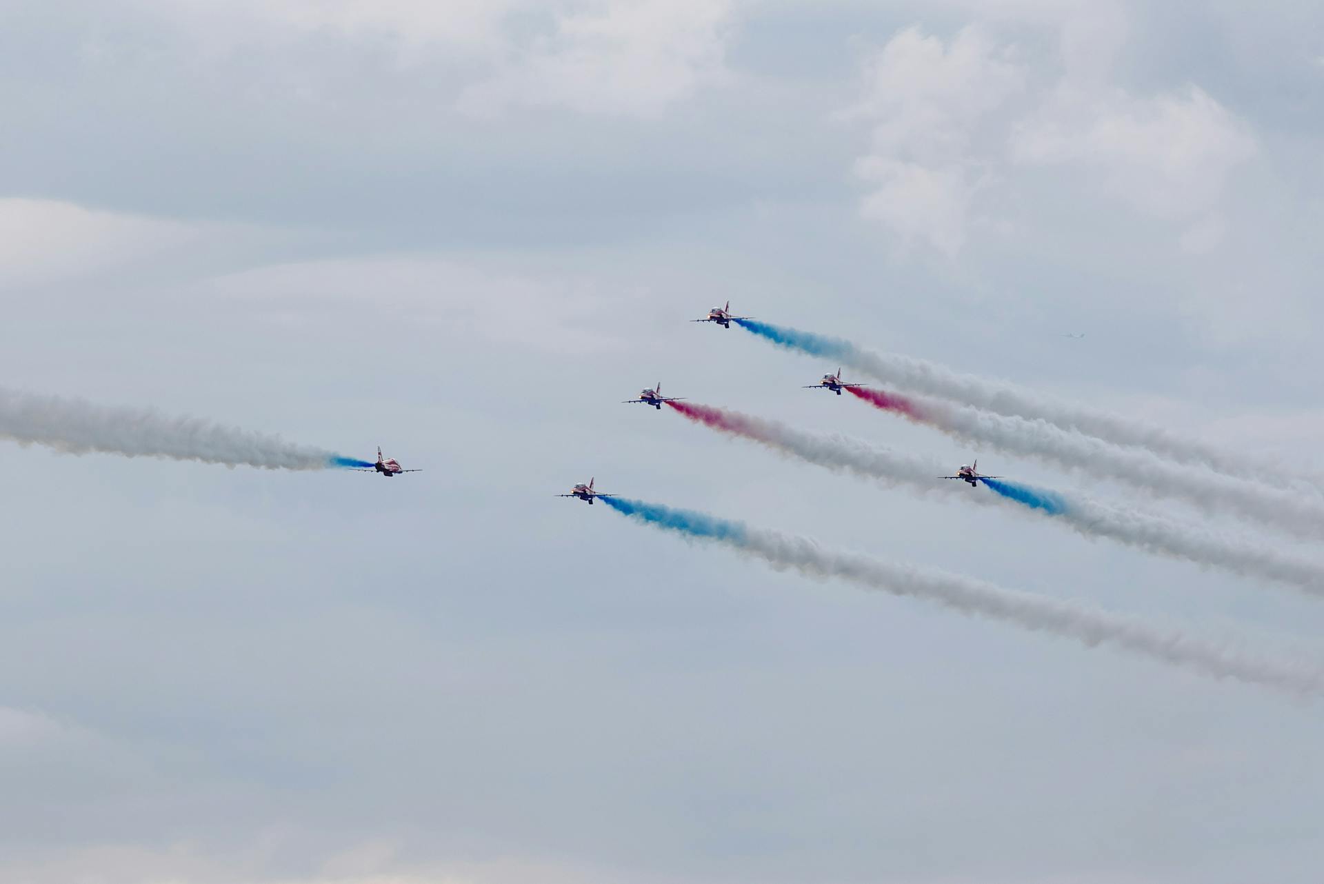 Air show with planes performing traces in cloudy sky