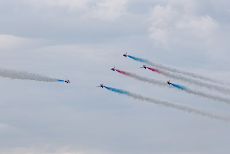 Air Show With Planes Performing Traces In Cloudy Sky