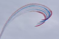 Low angle of aircrafts in row creating tricolor air tattoo in light sky on National Aviation Day