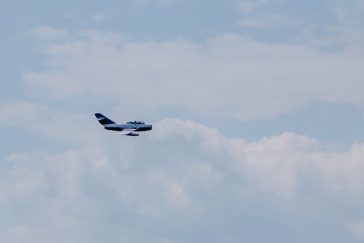 Military Airplane Flying In Cloudy Sky In Daytime