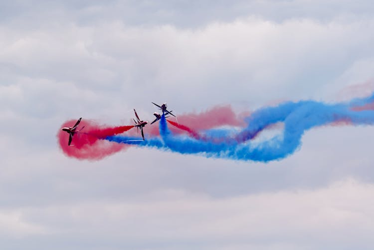 Performance Of Modern Military Aircraft With Colorful Smokes Flying In Cloudy Sky