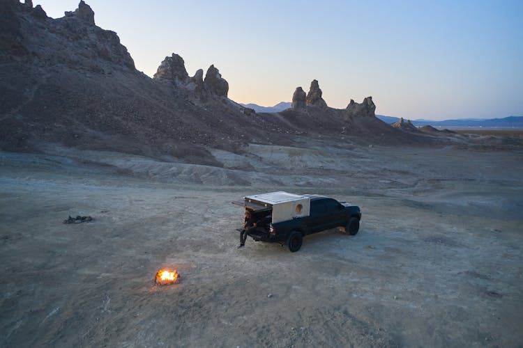 A Man Sitting At The Back Of A Camper Truck