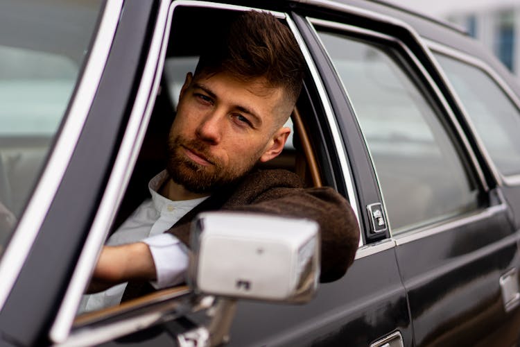 Confident Man With Trendy Hairstyle On Vintage Car