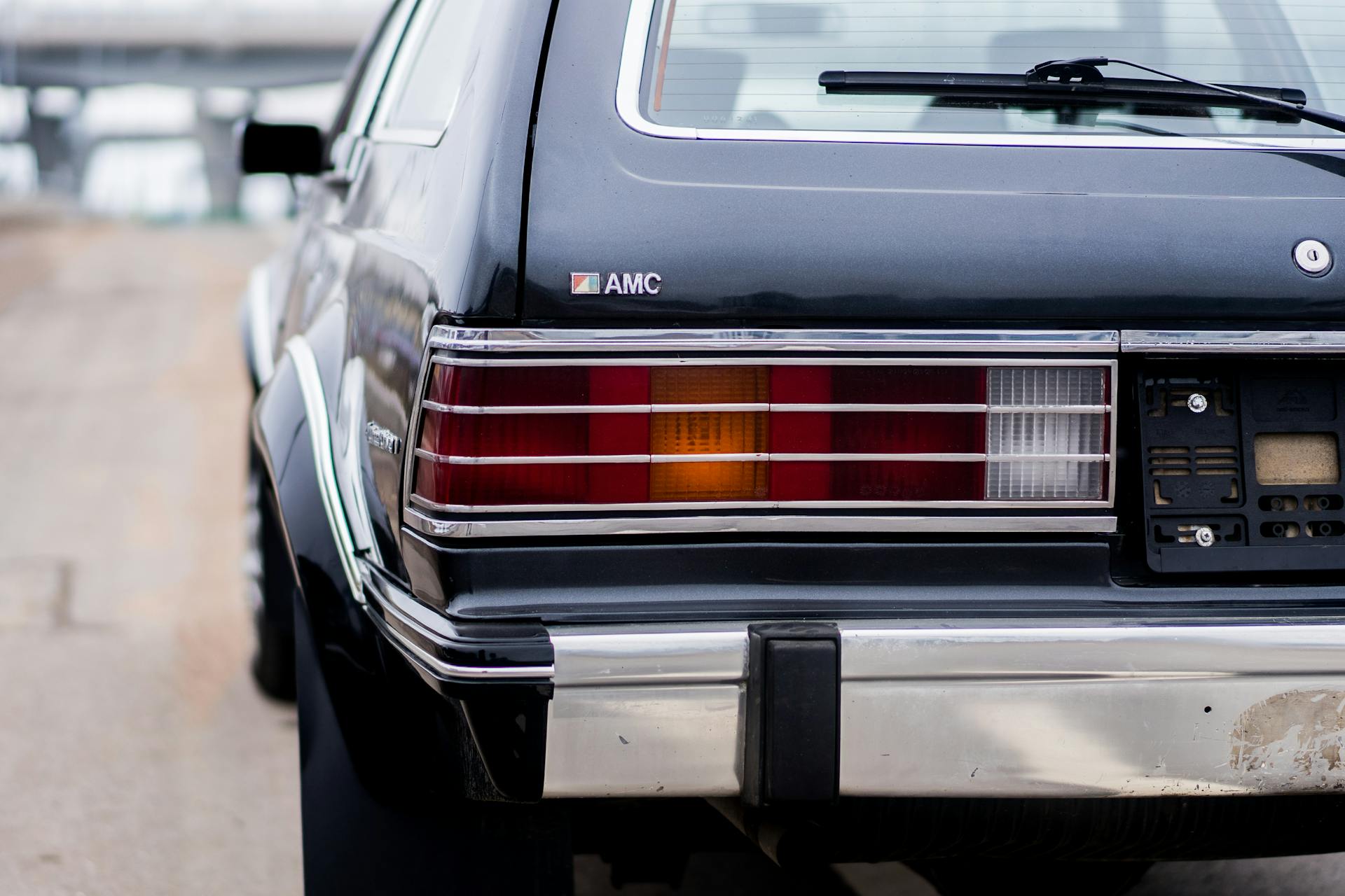 Close-up of a vintage AMC car with detailed taillights in an urban environment.