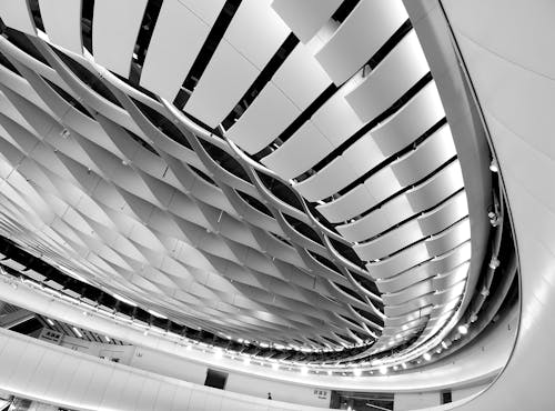 From above of black and white part of futuristic building in form of circle consisting of panels