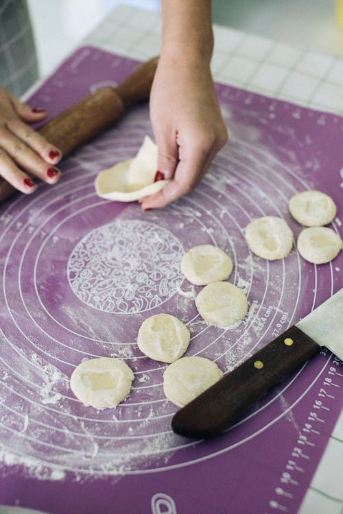 Free Person rolling Dough on a Purple Surface  Stock Photo