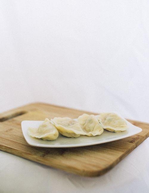 Free White plate of steamed dumplings on a wooden board captures Asian culinary delight. Stock Photo