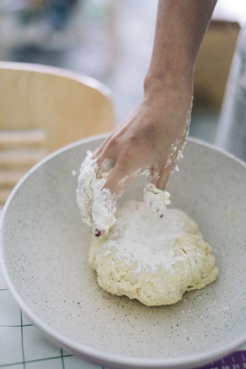Free Hand kneading dough in a bowl for baking. Flour dusted on fingers, indoor setting. Stock Photo