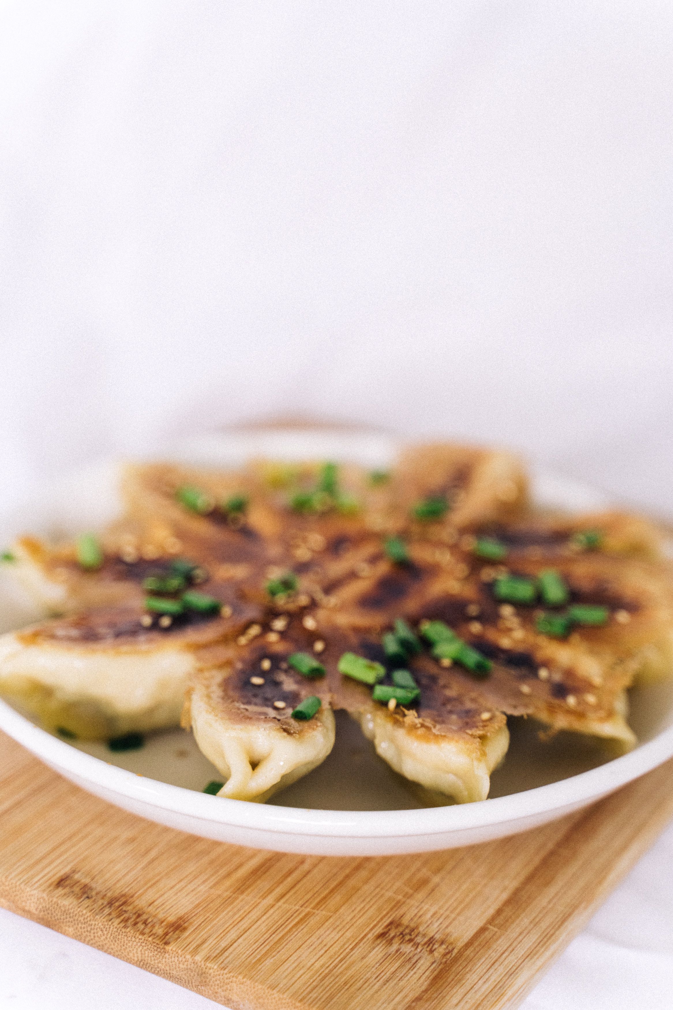 Homemade pork and garlic chive dumplings, pan-fried into potstickers with a crisp golden base and a juicy, savory filling.