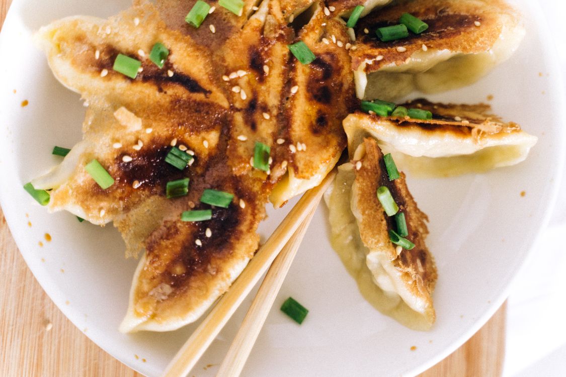 Pan-fried dumplings with garnishes Close-up of crispy pan-fried dumplings garnished with sesame seeds and green onions