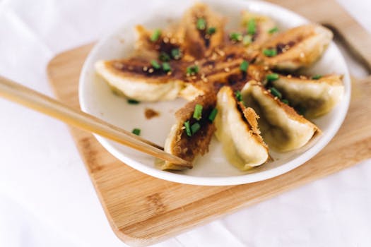 Close-up of crispy gyoza dumplings garnished with scallions and soy sauce.