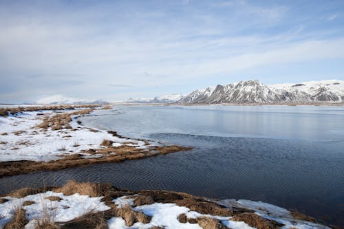 Snow Covered Mountain Near the Frozen Lake