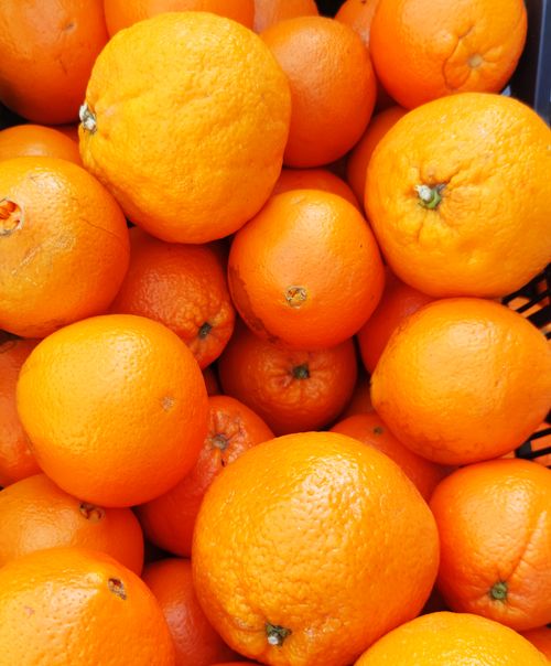 Free A vibrant collection of fresh oranges in a market basket, highlighting their bright color and texture. Stock Photo