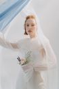Woman in White Wedding Dress Holding Bouquet of Flowers