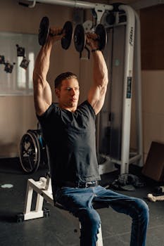 Muscular man lifting dumbbells in a gym setting, promoting fitness and strength.