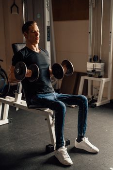 Man working out with dumbbells in a gym setting, focusing on strength training.