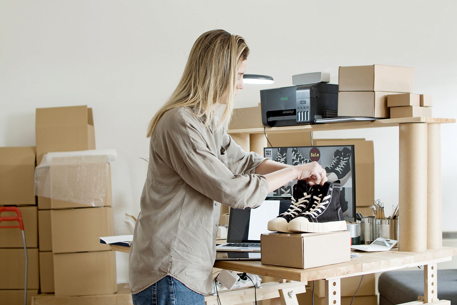 Small online shop owner packing trainers into a box for delivery