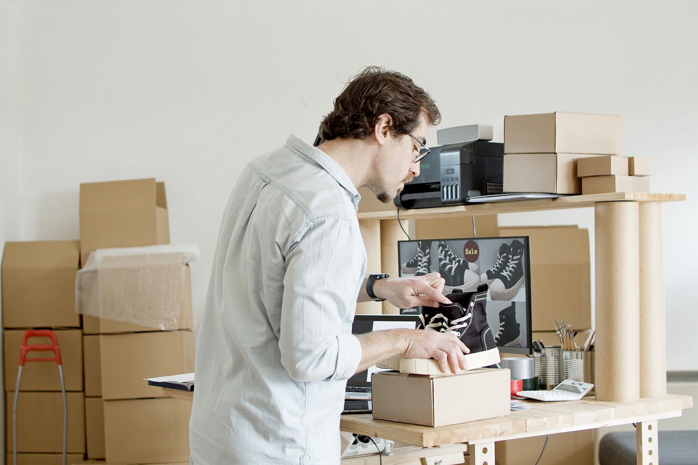 E-commerce operator packing customer orders in a fulfilment area