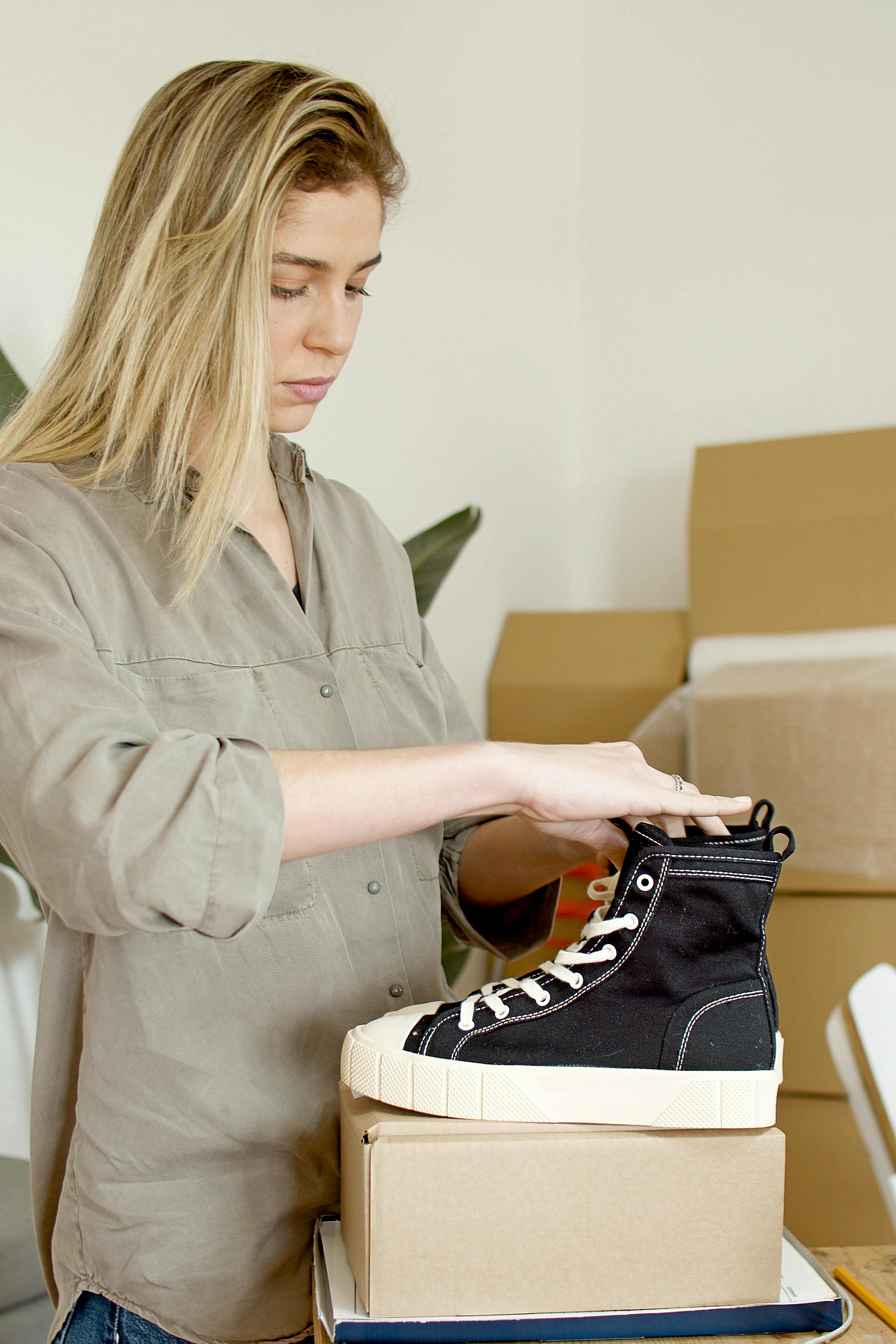 woman fixing the black shoes on top of the box