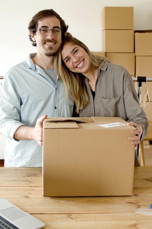 Couple Smiling while Holding the Package
