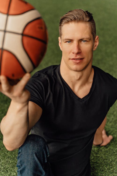 A Man in Black Shirt Holding a Ball