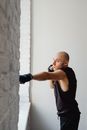 Man in Black Muscle Shirt with Hand Wraps Doing a Punch
