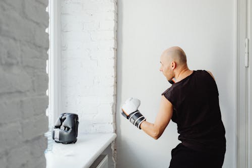 Man in Black Muscle Shirt Wearing Black and White Gloves