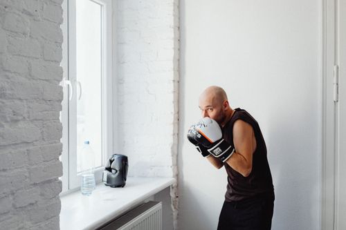 Free Bald man practicing boxing indoors, embodying fitness and a healthy lifestyle. Stock Photo
