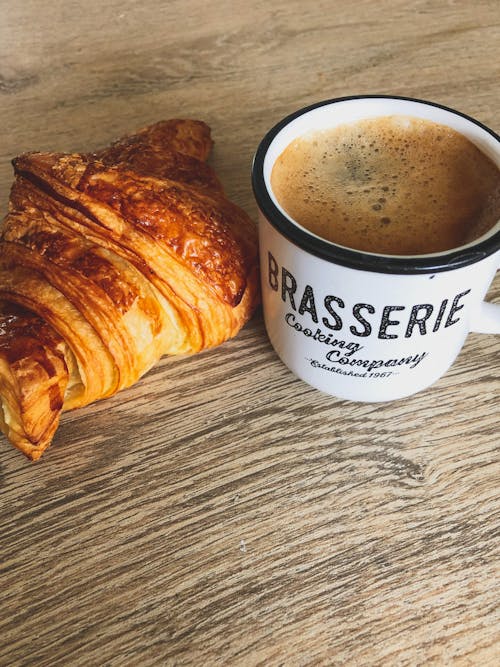 Free White Ceramic Mug With Coffee Beside Bread on Wooden Table Stock Photo