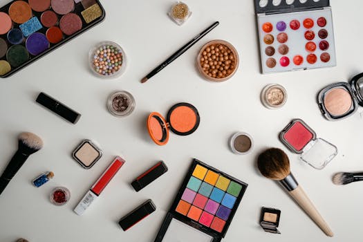 A vibrant collection of makeup and beauty products arranged in a flat lay on a white background.