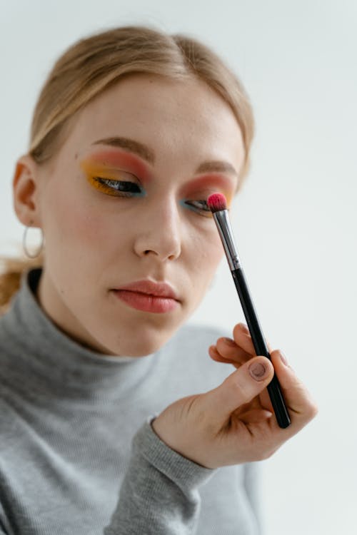 Free Close-Up Photo of a Woman Applying Eyeshadow on Her Eyelid Stock Photo