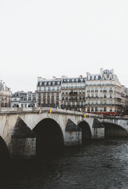 Charming view of a Parisian bridge and classic buildings along the river Seine.