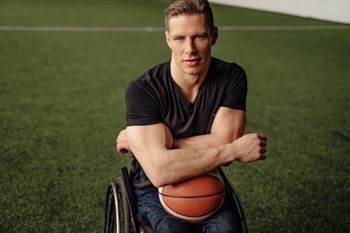 Photo of a Man in Wheelchair with a Ball