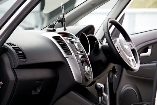 Close-up of a sleek car interior featuring a steering wheel and dashboard with chrome accents.