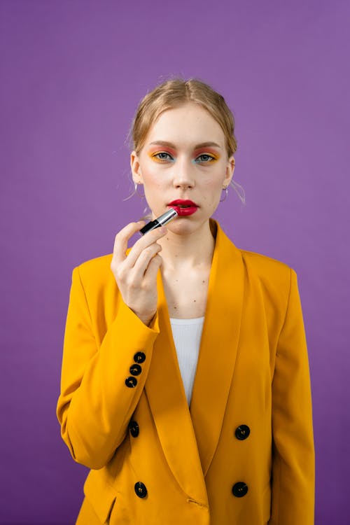 A Woman in Yellow Blazer Holding a Red Lipstick