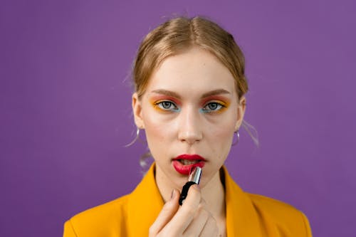Woman in Yellow Blazer Applying Red Lipstick
