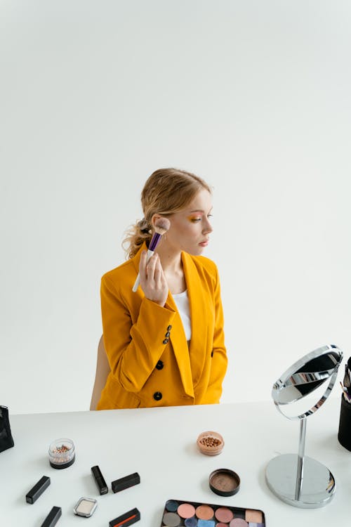 Woman in Yellow Blazer Holding a Makeup Brush