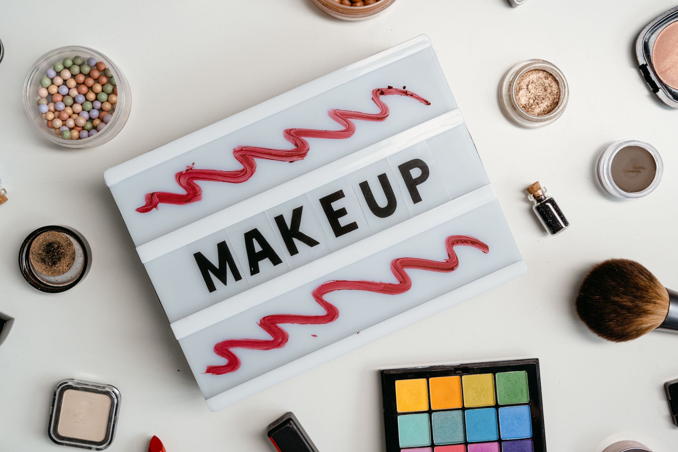Makeup Kits Beside a Sign with Makeup Text · Free Stock Photo