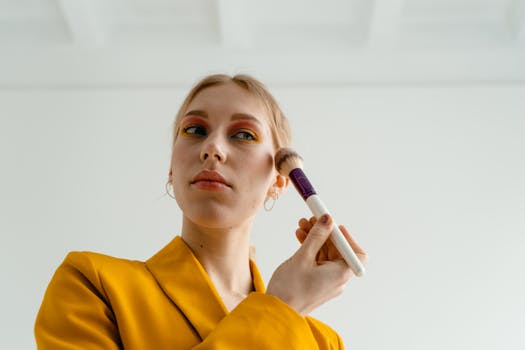 Woman in Yellow Blazer Putting Blusher on Her Face
