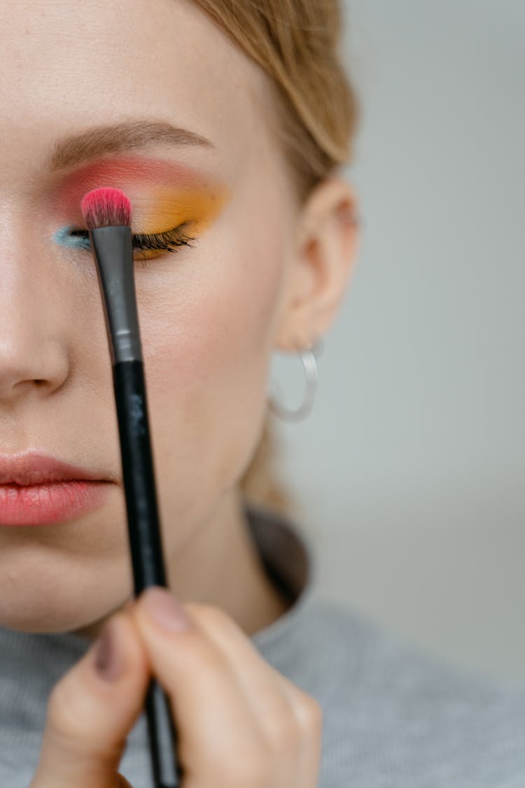 Woman In Gray Turtleneck Shirt Applying Eyeshadow